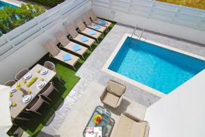普罗塔拉斯Villa Dina的享有带椅子和桌子的游泳池的顶部景致