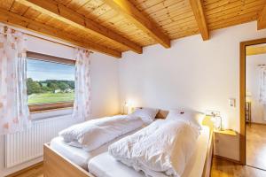 巴特乌拉赫卡特琳度假屋的一间卧室配有一张带白色床单的床和一扇窗户。