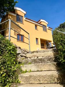 蒙丁-迪巴什图Casa Amarela - Mondim de Basto的黄色的房子,有楼梯通往