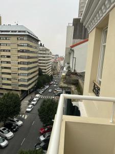 拉科鲁尼亚CoruñaFlat Apartamentos con encanto en el centro de A Coruña的享有城市街道的停车车辆景致