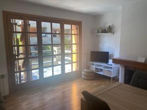 卡尼略Apartamento Refugi的客厅设有大窗户和电视。