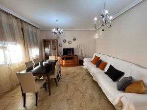 利纳雷斯Casa grande de tres plantas的一间带白色沙发的客厅和一间用餐室