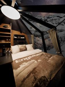 英格堡特吕布湖高山宾馆的卧室配有一张大床,墙上挂着一张海报