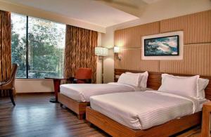 甘托克Staynest gangtok 300 mtr from MALL ROAD的酒店客房设有两张床和窗户。