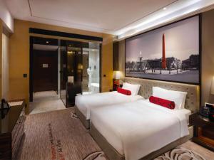 广州Sofitel Guangzhou Sunrich的酒店客房 - 带两张带红色枕头的床