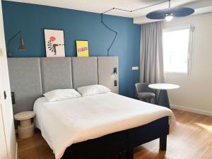马蒂格宜必思马蒂格中央酒店的一间卧室设有一张大床和蓝色的墙壁