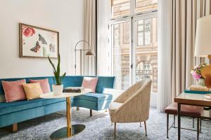 巴黎Hôtel du Louvre, in The Unbound Collection by Hyatt的客厅配有蓝色的沙发和桌子