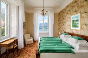 贝拉吉奥Grand Hotel Villa Serbelloni - 150 Years of Grandeur的一间卧室配有一张带绿色床单的大床
