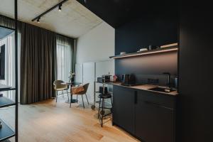 奥尔登堡HIIVE Oldenburg的厨房设有黑色的墙壁和桌椅