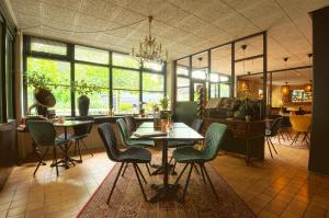 洛赫姆Bosrijk Ruighenrode的一间在房间内配有桌椅的餐厅