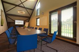 洛赫姆Bosrijk Ruighenrode的一间会议室,配有桌子和蓝色椅子