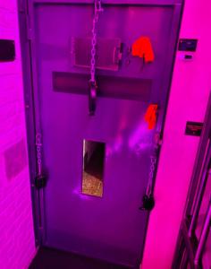 图尔奈Secret Room votre chambre coquine et insolite en espace privatif a Tournai的一间房间里带链子的紫色门