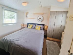 赛伦塞斯特Lakeside Cotswold Holiday Home的一间卧室配有一张带两个黄色枕头的床