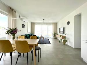 塞内奇Klimatizovaný Apartmánový dom s vírivkou, 10A的用餐室以及带桌椅的起居室。