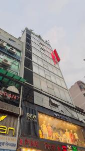 达卡Hotel Prime Inn Mirpur 10的前面有一间商店的高楼