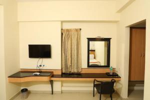 塞勒姆Hotel Shrie Shaanth的客房设有一张带电脑和镜子的书桌