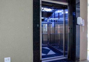 乌巴图巴JARDIM DAS PALMEIRAS II - HOME RESORT的大楼内电梯的玻璃门