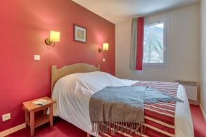 圣拉里苏朗Résidence Pierre & Vacances Les Rives de l'Aure的一间卧室设有一张红色墙壁和窗户的床