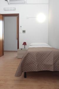卡塞勒托瑞尼斯La Porta del Sole的一间白色的卧室,配有床和门