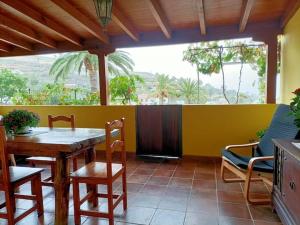 AlajeróCasa Tajonaje - Entorno rural的用餐室配有桌椅和黄色墙壁