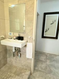 内尔斯普雷特Endonini House的浴室设有白色水槽和镜子