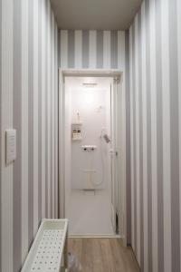 Zentsuji深山邸miyama-tei的设有带条纹墙面淋浴的浴室
