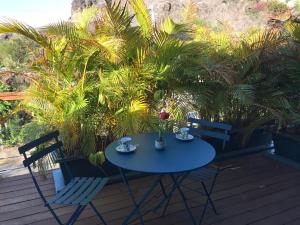 圣保罗Appartement Artistique de Boucan Canot的棕榈树甲板上的蓝色桌子和椅子