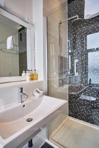 奥本马凯斯旅馆的白色的浴室设有水槽和淋浴。