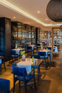 埃因霍温埃因霍温凡德瓦克酒店的一间带桌子和蓝色椅子的餐厅