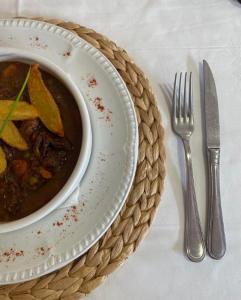 阿洛斯Hotel & Restaurante Peña的 ⁇ 头和刀子盘上的一碗汤