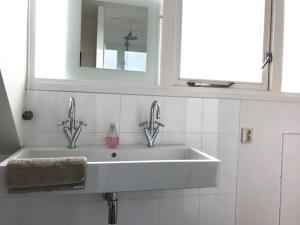 布勒克伦Penthouse with a view的浴室水槽设有2个水龙头和镜子