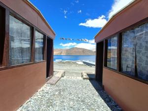 MerukNative Retreat Cottage , Pangong ladakh UT的一座带窗户的建筑,享有水景