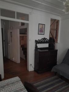 里斯本Chiado / Carmo Small Artist Lodge的一间带钢琴的客厅和一间带楼梯的房间