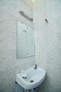 蒙巴萨Mombasa Railway Gardens Hotel的浴室设有白色水槽和镜子