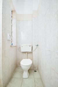 蒙巴萨Mombasa Railway Gardens Hotel的一间位于客房内的白色卫生间的浴室