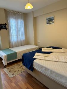 恰纳卡莱Efe Can Apart Otel的一间卧室设有两张床和窗户。