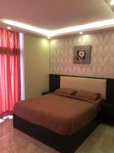 索瓦马مشروع ميريت البحر الميت السكني العائلي的一间卧室配有床和红色窗帘