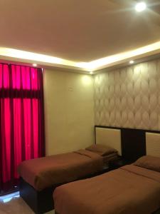 索瓦马مشروع ميريت البحر الميت السكني العائلي的一间设有两张床和红色窗帘的房间