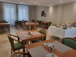 亚历山德里亚力士酒店的用餐室配有木桌、椅子和桌子