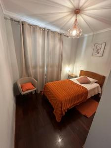 丰沙尔Apartamento Santiago I的一间卧室配有一张带橙色毯子的床