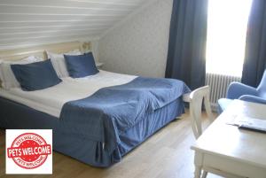 塔尔伯格托尔堡斯农场酒店的一间卧室配有一张带蓝色床单的床和一张桌子。