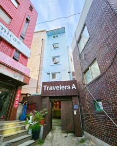 首尔Travelers A Korea Hostel的带有读取旅客的标志的建筑物