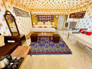 斋沙默尔Griat sandy desert camp jaisalmer的一间设有床、沙发和地毯的房间