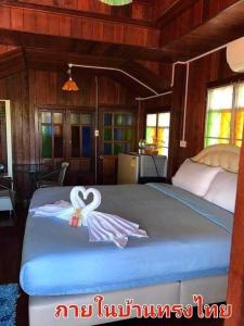 Ban Non Na YaoThe Memorize Resort的一间卧室配有一张带两个天鹅的床