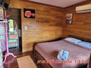 Ban Non Na YaoThe Memorize Resort的木墙客房内的小床