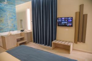 巴科利Shanti Rooms & Apartments的墙上设有电视的浴室