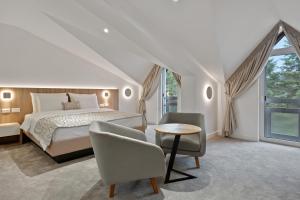 巴尼亚科维利亚查Hotel Podrinje的卧室配有一张床和一张桌子及椅子