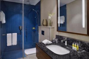 阿可贺巴Marriott Executive Apartments Al Khobar的一间带水槽和玻璃淋浴的浴室