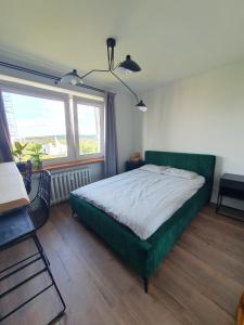 克拉科夫Apartamenty Cześć Kraków的一间卧室设有一张绿色的床和一个窗户。