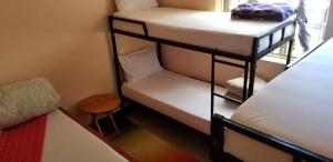 阿鲁沙Maasai Hostel Tanzania的客房设有两张双层床和一张桌子。